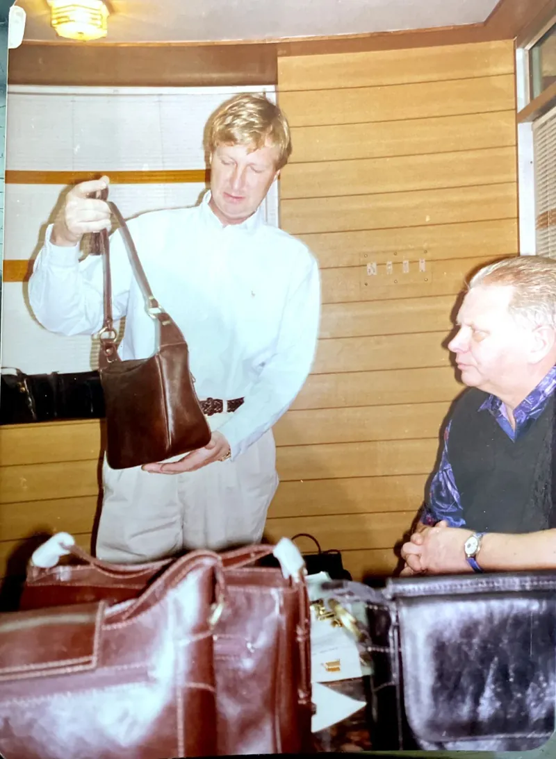 Family archive photograph of overseas buyers reviewing leather bags