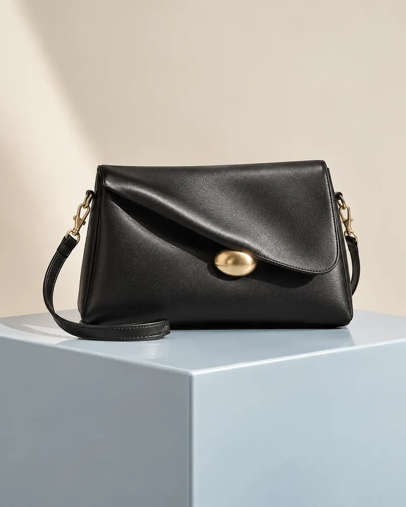 Black leather evening bag with a sculptural gold clasp